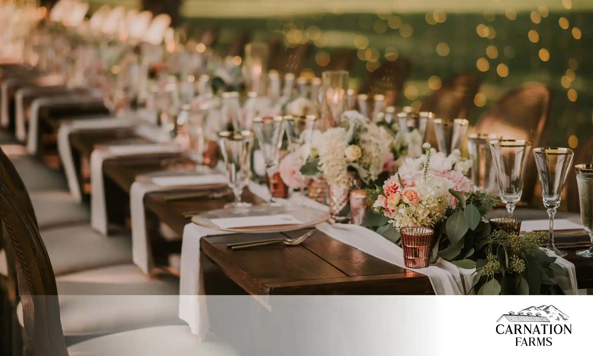 Destination wedding reception table setup with floral arrangements and candles.