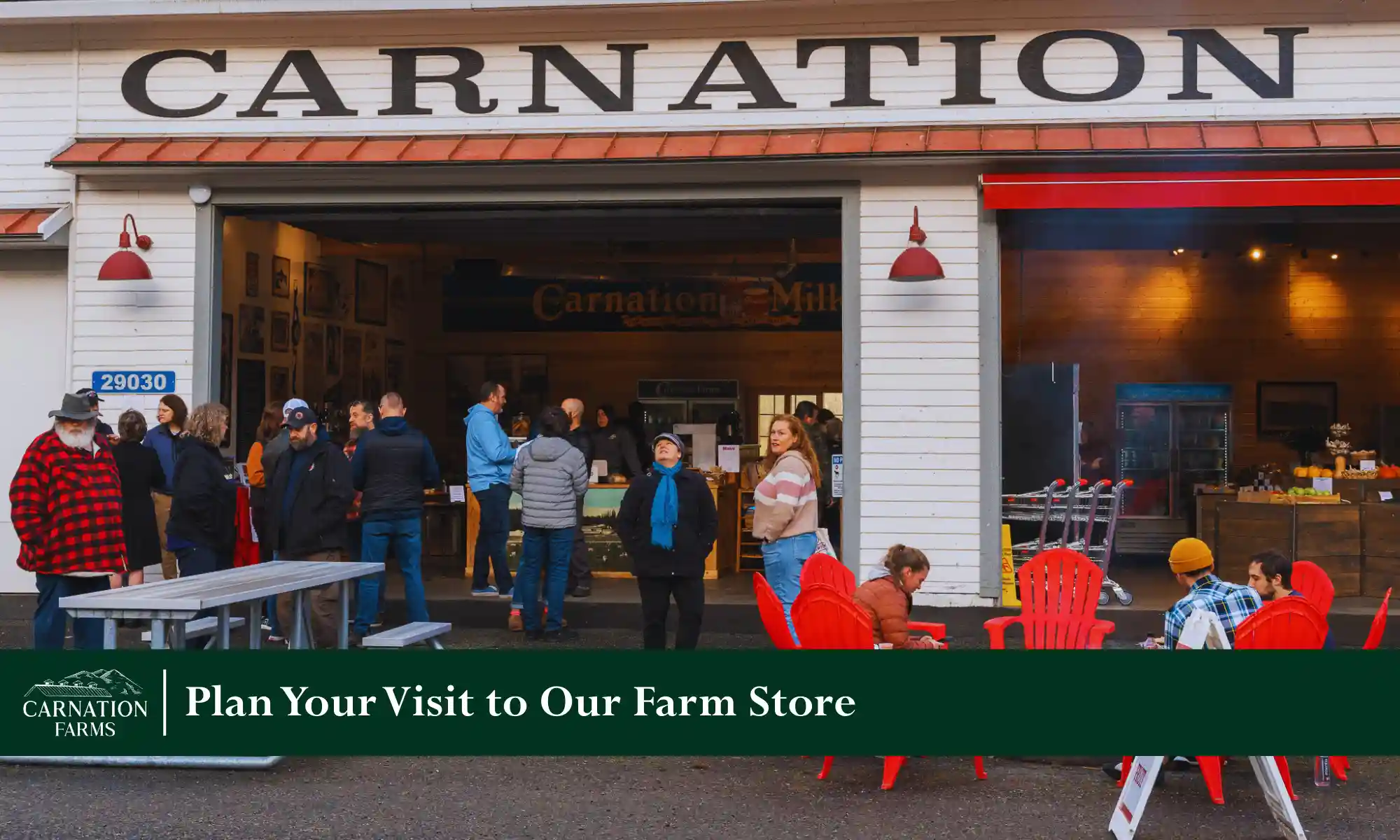 Farmer holding fresh carrots and bags of locally grown produce at the Carnation Farmstand.
